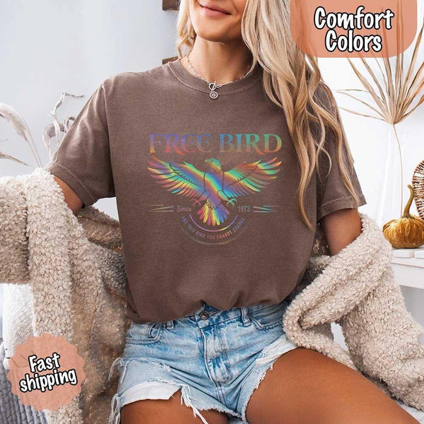 May include a vintage-inspired design with the phrase “Free Bird” on a Comfort Colors tee, channeling classic rock band style and retro music vibes perfect for fans of timeless tunes.