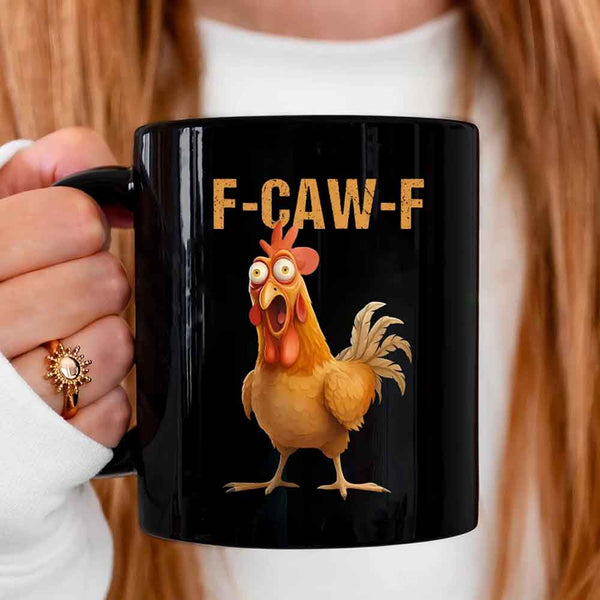 Black mug with a cartoon chicken and 'F-CAW-F' text held by a person.
