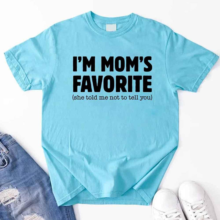 May include a unisex t-shirt reading “I’m Mom’s Favorite” in bold font, displayed on a flat lay or model, ideal for Mother’s Day gifting.