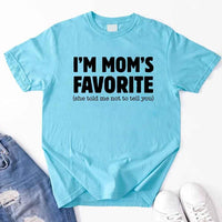 May include a unisex t-shirt reading “I’m Mom’s Favorite” in bold font, displayed on a flat lay or model, ideal for Mother’s Day gifting.