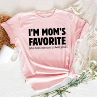 May include a unisex t-shirt reading “I’m Mom’s Favorite” in bold font, displayed on a flat lay or model, ideal for Mother’s Day gifting.