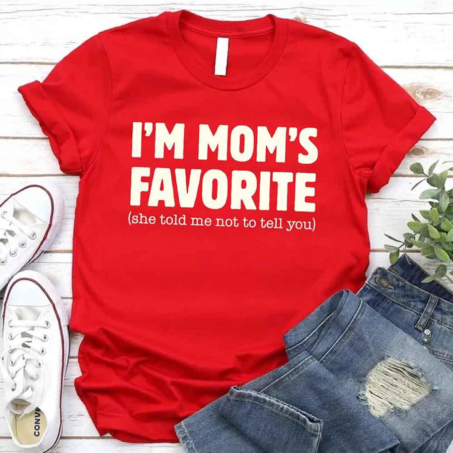 May include a unisex t-shirt reading “I’m Mom’s Favorite” in bold font, displayed on a flat lay or model, ideal for Mother’s Day gifting.