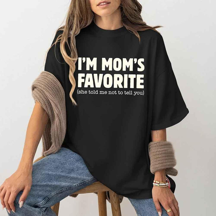 May include a unisex t-shirt reading “I’m Mom’s Favorite” in bold font, displayed on a flat lay or model, ideal for Mother’s Day gifting.
