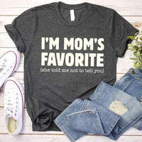 May include a unisex t-shirt reading “I’m Mom’s Favorite” in bold font, displayed on a flat lay or model, ideal for Mother’s Day gifting.