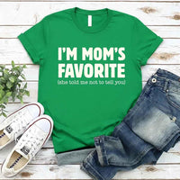May include a unisex t-shirt reading “I’m Mom’s Favorite” in bold font, displayed on a flat lay or model, ideal for Mother’s Day gifting.