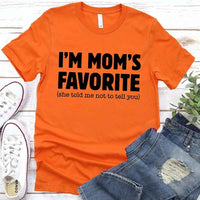 May include a unisex t-shirt reading “I’m Mom’s Favorite” in bold font, displayed on a flat lay or model, ideal for Mother’s Day gifting.