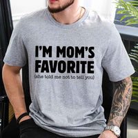 May include a unisex t-shirt reading “I’m Mom’s Favorite” in bold font, displayed on a flat lay or model, ideal for Mother’s Day gifting.