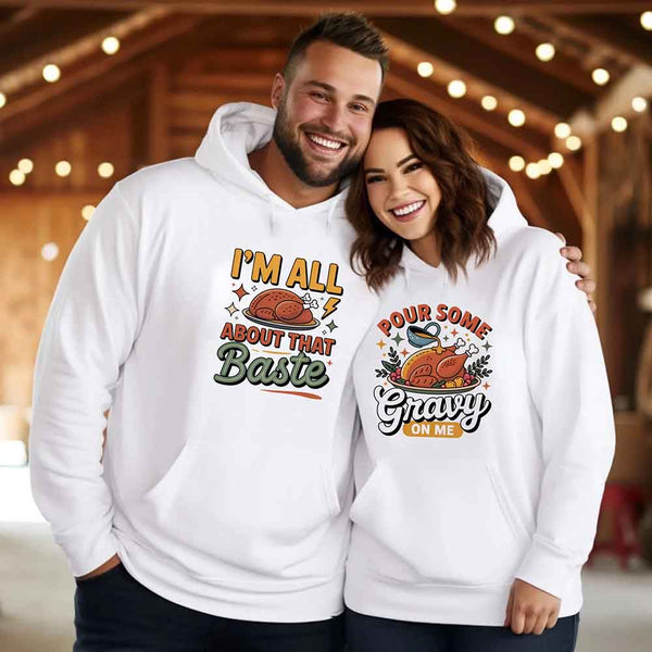 Two people wearing white hoodies with humorous Thanksgiving graphics and text.