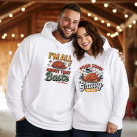 Two people wearing white hoodies with humorous Thanksgiving graphics and text.