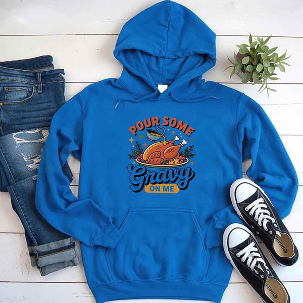Blue hoodie with humorous design, jeans, and sneakers on a wooden surface