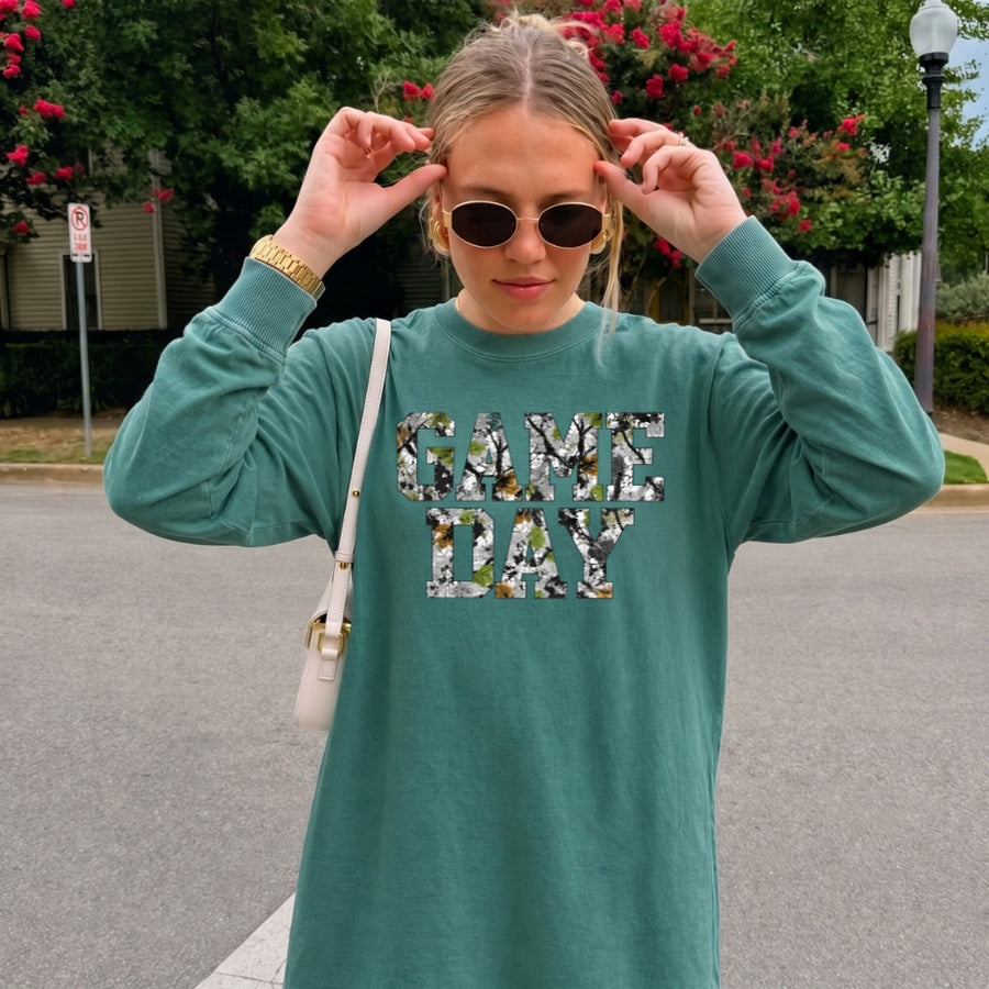 May include a Game Day Camo Print Comfort Colors Unisex Long Sleeve featuring a football-inspired camo print design.