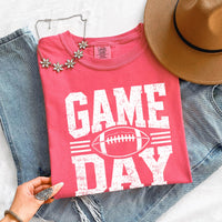 May include a Comfort Colors T-shirt featuring a distressed Game Day graphic with a football design, perfect for football fans, tailgates, watch parties, and sporting events.