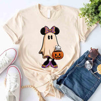 Beige t-shirt with a ghost character holding a pumpkin, paired with jeans and sneakers on a light background.