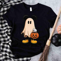 Black t-shirt with a ghost design holding a pumpkin, placed on a checkered cloth with Halloween decorations.