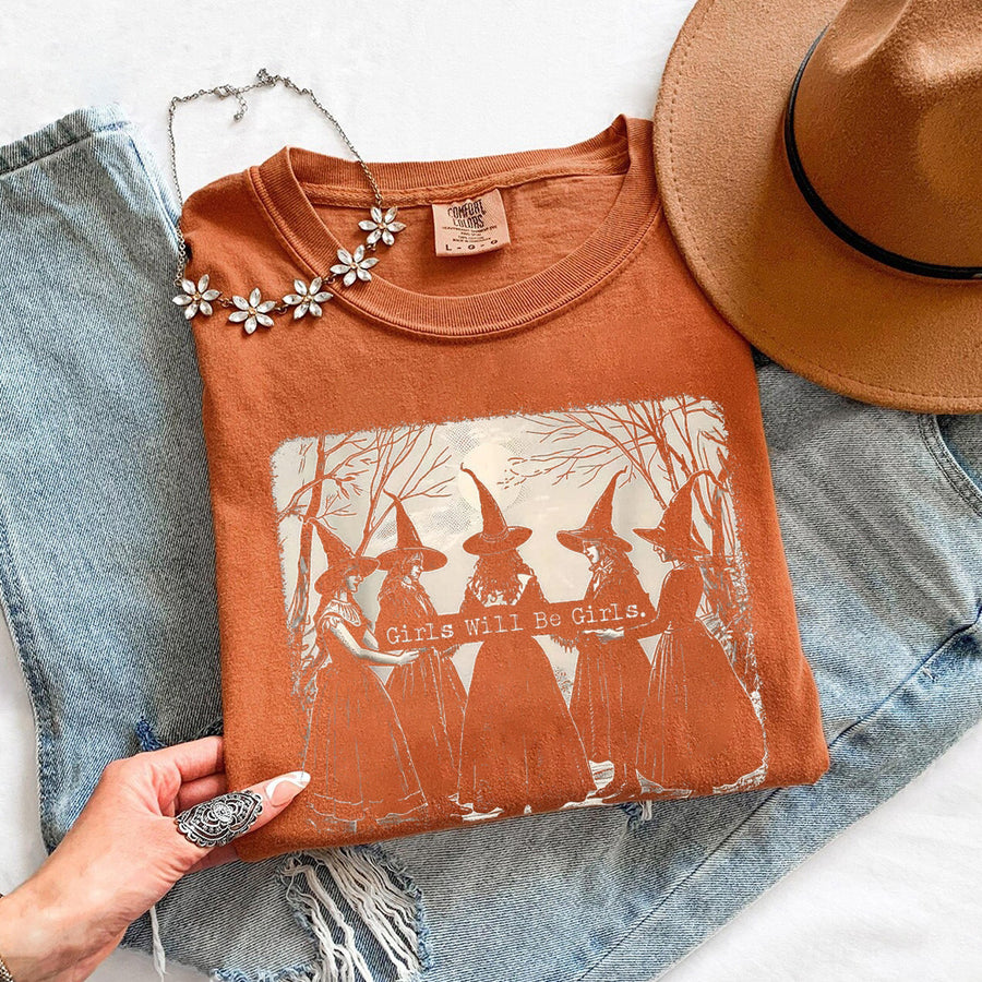 May include Girls Will Be Girls Comfort Colors Halloween t-shirt with festive graphic and relaxed unisex garment-dyed fit
