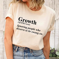 May include a unisex graphic t-shirt featuring the word “Growth” presented as a dictionary-style definition, paired with clean typography and an uplifting message that emphasizes progress, learning, and personal development.