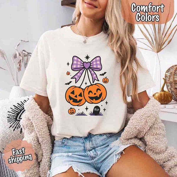 May include Halloween cherries graphic with two jack-o’-lantern pumpkins tied by a purple plaid bow, surrounded by bats, stars, and gravestone – cute spooky shirt design.