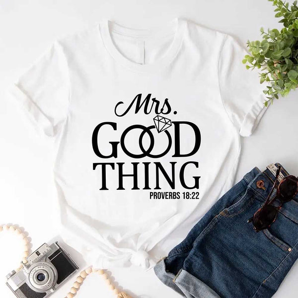 White t-shirt with 'Mrs. Good Thing' text on a white background with jeans and sunglasses.