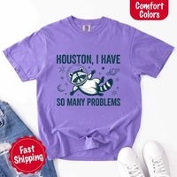 May include a cartoon raccoon in a space helmet floating in space, surrounded by stars, a planet with rings, and a crescent moon. The text reads: “HOUSTON, I HAVE SO MANY PROBLEMS,” parodying the famous Apollo 13 quote with a humorous twist.
