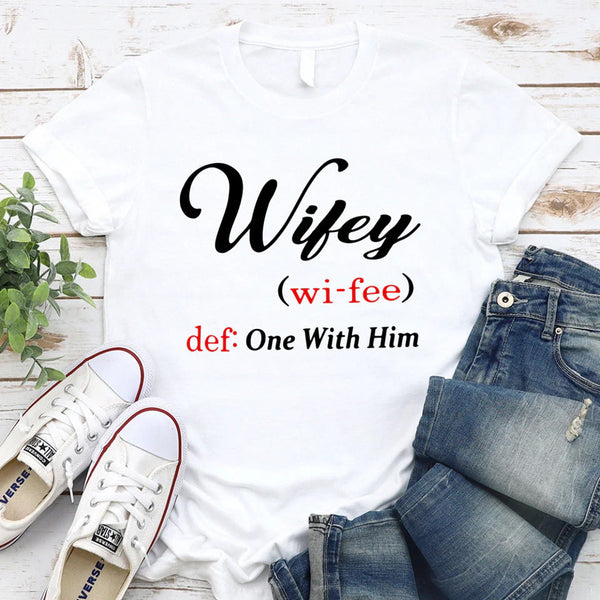 May include Wifey text graphic with definition style design, showing ‘Wifey (wi-fee) def: One With Him’ in black and red font – Christian inspirational shirt.