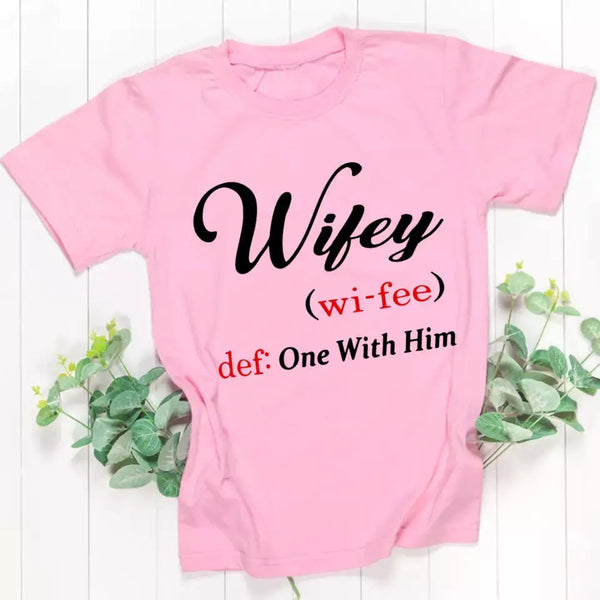 May include Wifey text graphic with definition style design, showing ‘Wifey (wi-fee) def: One With Him’ in black and red font – Christian inspirational shirt.