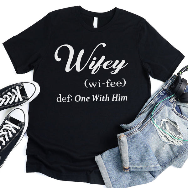 May include Wifey text graphic with definition style design, showing ‘Wifey (wi-fee) def: One With Him’ in black and red font – Christian inspirational shirt.