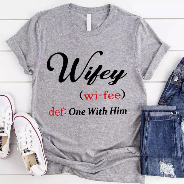 May include Wifey text graphic with definition style design, showing ‘Wifey (wi-fee) def: One With Him’ in black and red font – Christian inspirational shirt.
