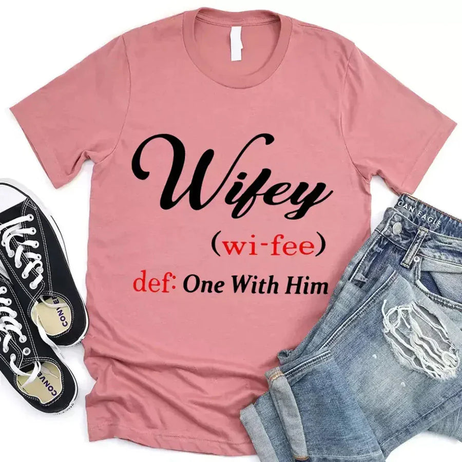 May include Wifey text graphic with definition style design, showing ‘Wifey (wi-fee) def: One With Him’ in black and red font – Christian inspirational shirt.