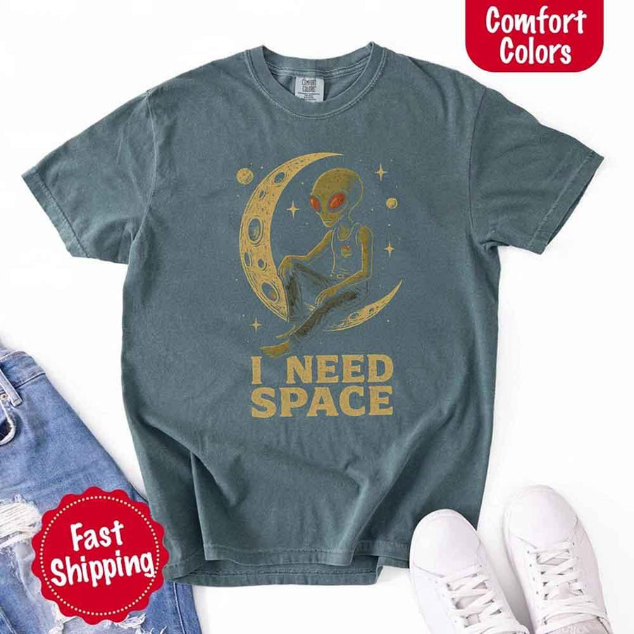 May include a folded black Comfort Colors T-shirt with “i need space” printed in a gothic font, laid over denim jeans for a bold, moody, and alternative vibe.