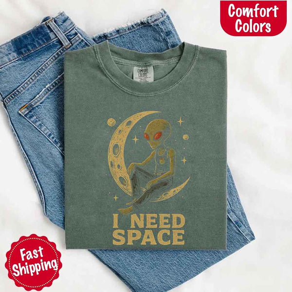May include a folded black Comfort Colors T-shirt with “i need space” printed in a gothic font, laid over denim jeans for a bold, moody, and alternative vibe.