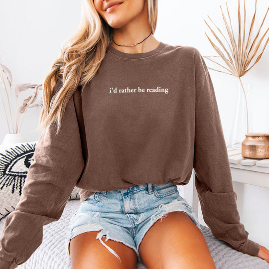 May include an I’d Rather Be Reading Comfort Colors Long Sleeve featuring a classic book lover statement design on a casual shirt.
