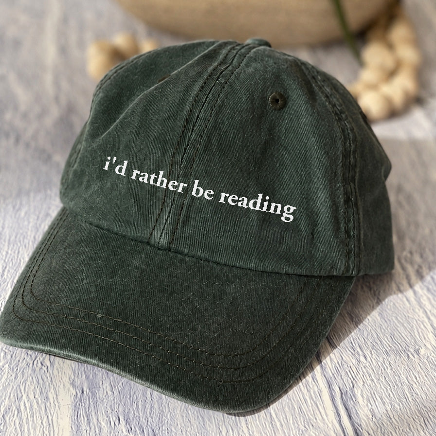 May include an I’d Rather Be Reading Pigment-Dyed Cap featuring a book lover statement on a casual pigment-dyed baseball cap.