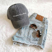 May include an I’d Rather Be Reading Pigment-Dyed Cap featuring a book lover statement on a casual pigment-dyed baseball cap.