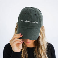 May include an I’d Rather Be Reading Pigment-Dyed Cap featuring a book lover statement on a casual pigment-dyed baseball cap.