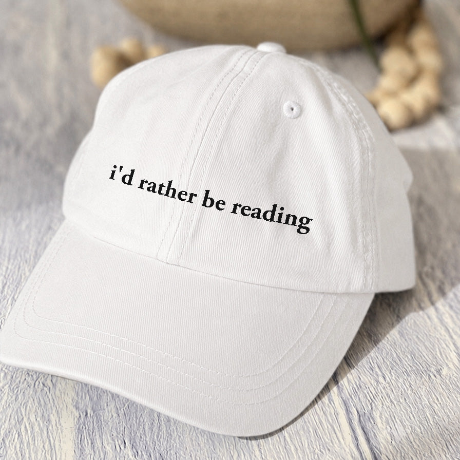 May include an I’d Rather Be Reading Pigment-Dyed Cap featuring a book lover statement on a casual pigment-dyed baseball cap.
