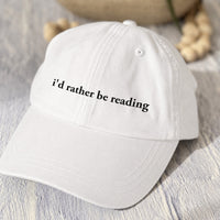 May include an I’d Rather Be Reading Pigment-Dyed Cap featuring a book lover statement on a casual pigment-dyed baseball cap.