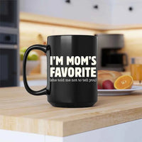 Black mug with 'I'm Mom's Favorite (she told me not to tell you)' text on a kitchen counter.
