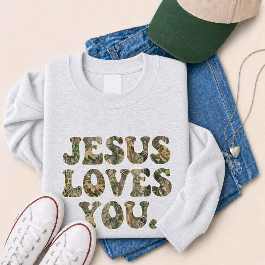 May include Jesus Loves You camouflage sweatshirt with Christian faith graphic design and relaxed unisex fit