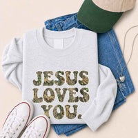 May include Jesus Loves You camouflage sweatshirt with Christian faith graphic design and relaxed unisex fit