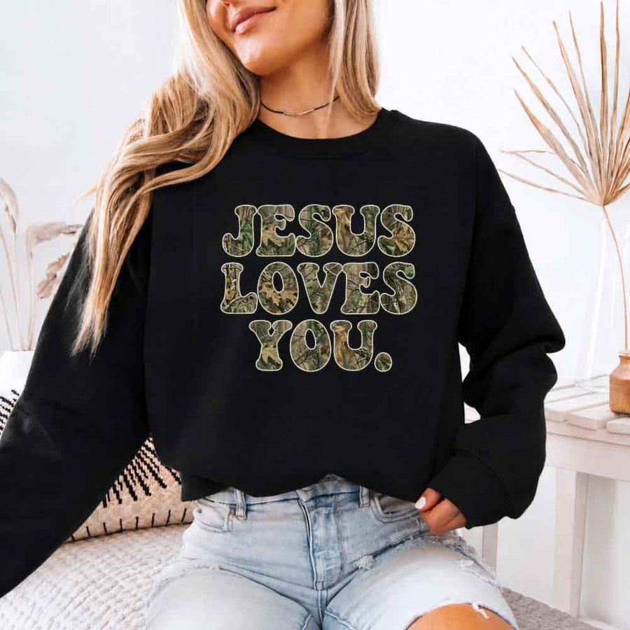 May include Jesus Loves You camouflage sweatshirt with Christian faith graphic design and relaxed unisex fit