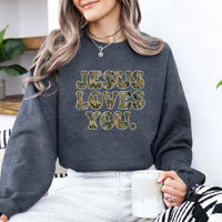 May include Jesus Loves You camouflage sweatshirt with Christian faith graphic design and relaxed unisex fit