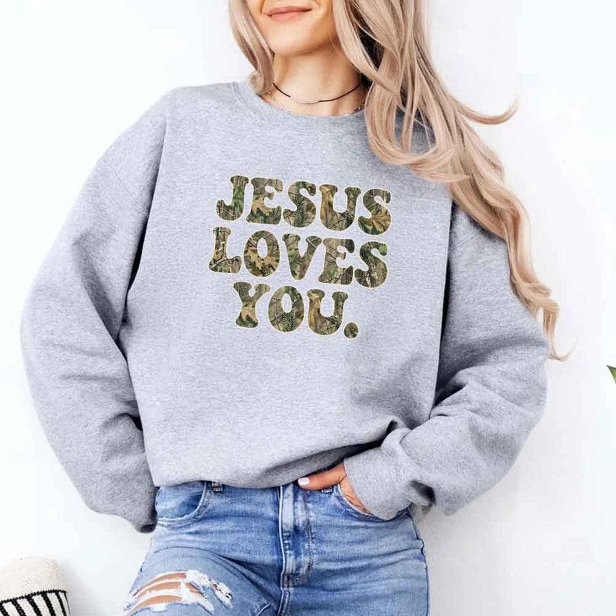 May include Jesus Loves You camouflage sweatshirt with Christian faith graphic design and relaxed unisex fit