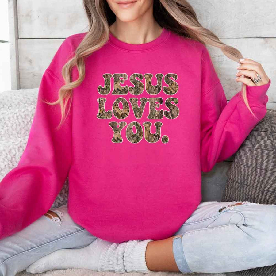 May include Jesus Loves You camouflage sweatshirt with Christian faith graphic design and relaxed unisex fit