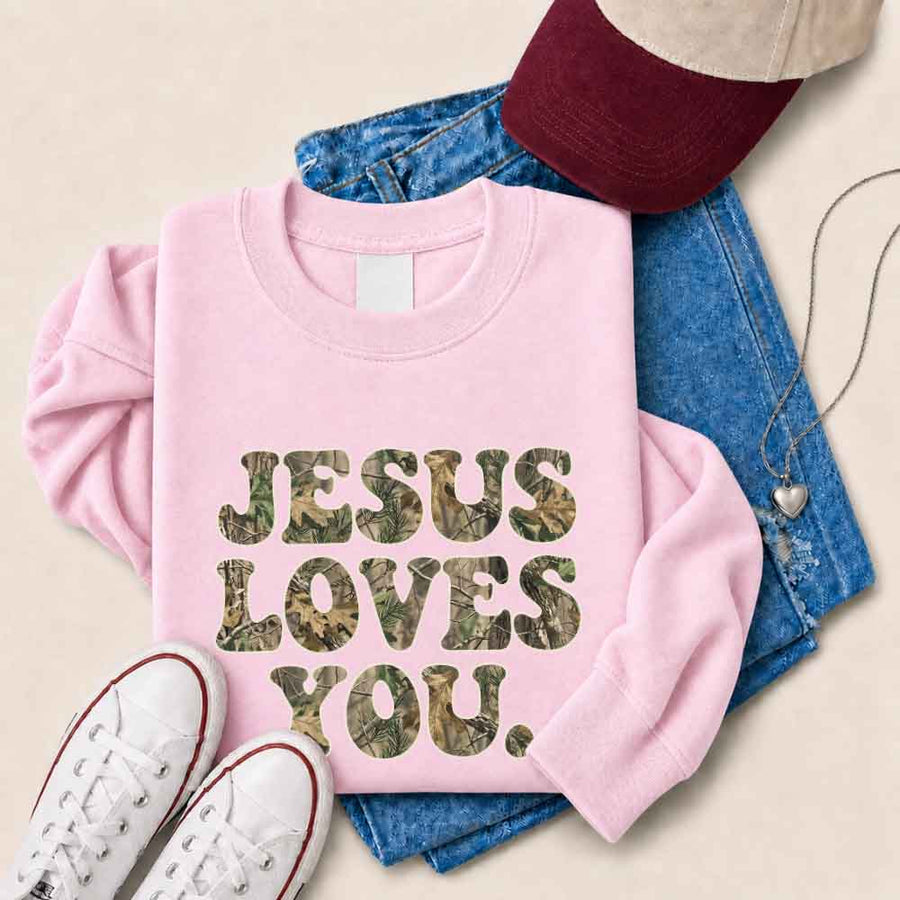 May include Jesus Loves You camouflage sweatshirt with Christian faith graphic design and relaxed unisex fit