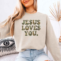 May include Jesus Loves You camouflage sweatshirt with Christian faith graphic design and relaxed unisex fit