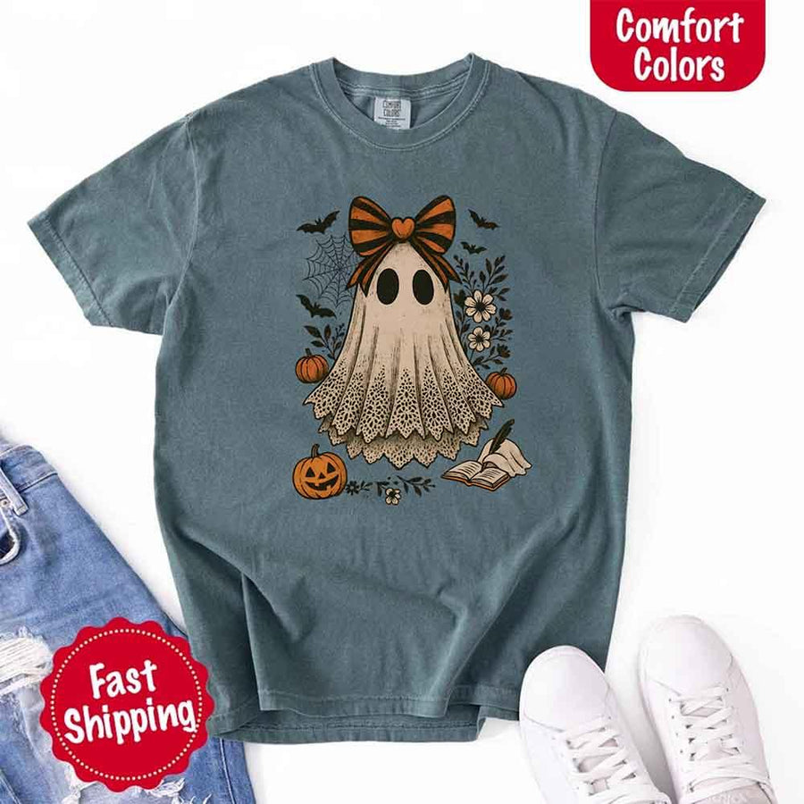May include lace ghost Halloween graphic with black eyes, orange striped bow, pumpkins, spider web, bats, flowers, and open spell book – spooky vintage shirt design.