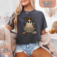 May include lace ghost Halloween graphic with black eyes, orange striped bow, pumpkins, spider web, bats, flowers, and open spell book – spooky vintage shirt design.