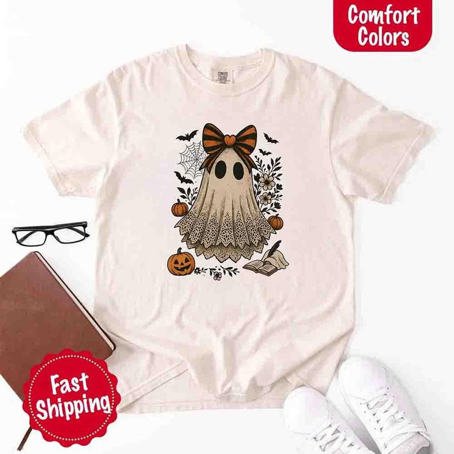May include lace ghost Halloween graphic with black eyes, orange striped bow, pumpkins, spider web, bats, flowers, and open spell book – spooky vintage shirt design.