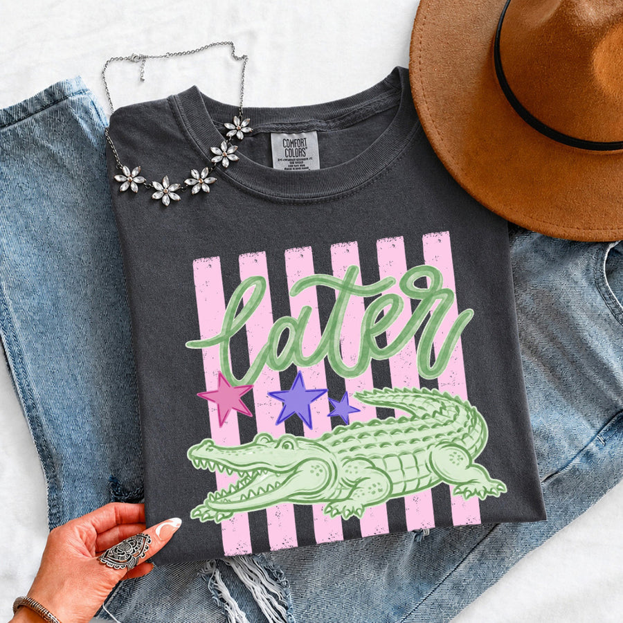 May include a Later Alligator Comfort Colors Tee featuring a playful alligator-inspired statement design on a casual short-sleeve shirt.
