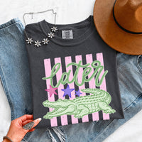 May include a Later Alligator Comfort Colors Tee featuring a playful alligator-inspired statement design on a casual short-sleeve shirt.